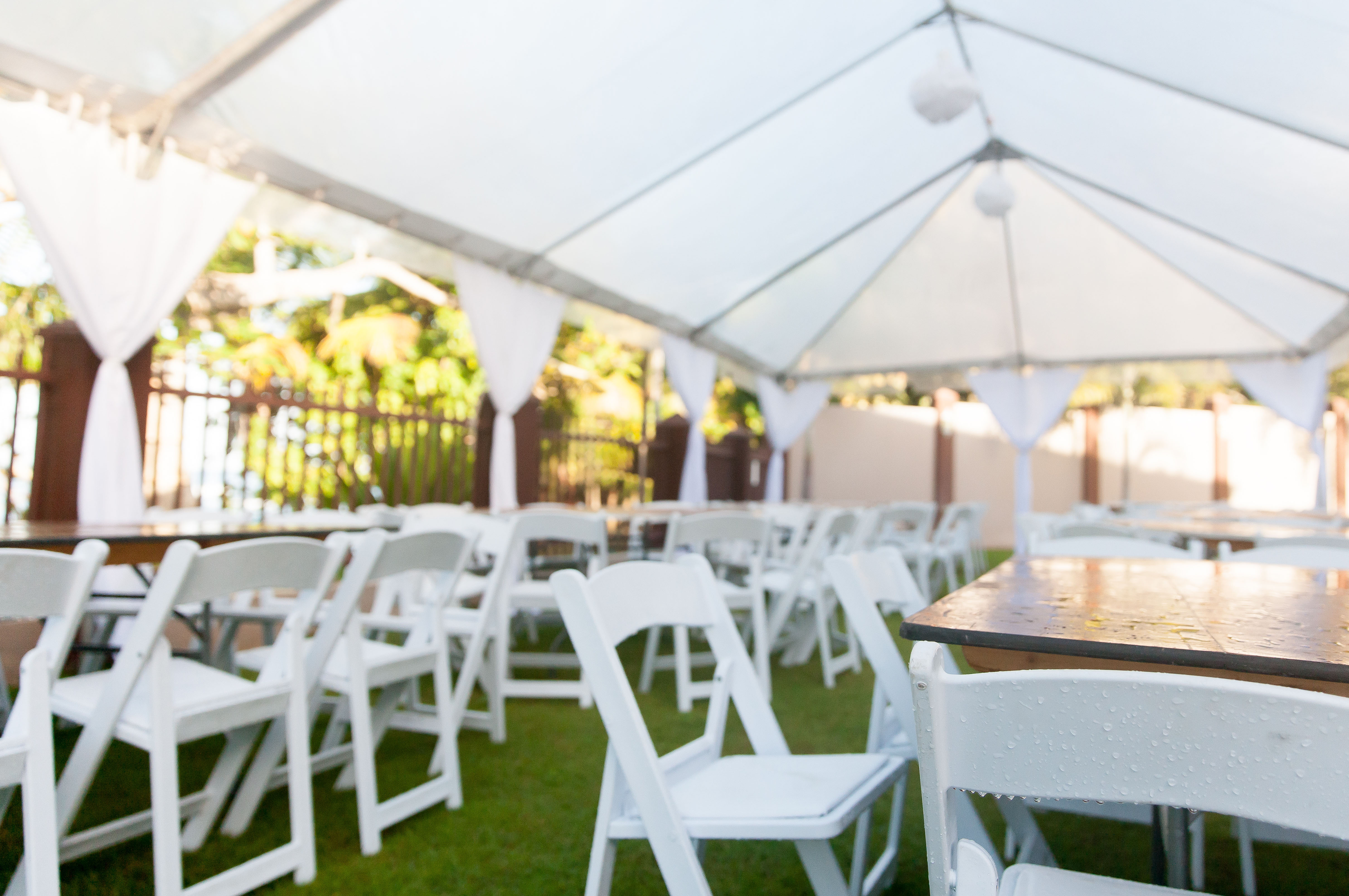 Wedding Tent - A group of chairs and tables under a white tent.